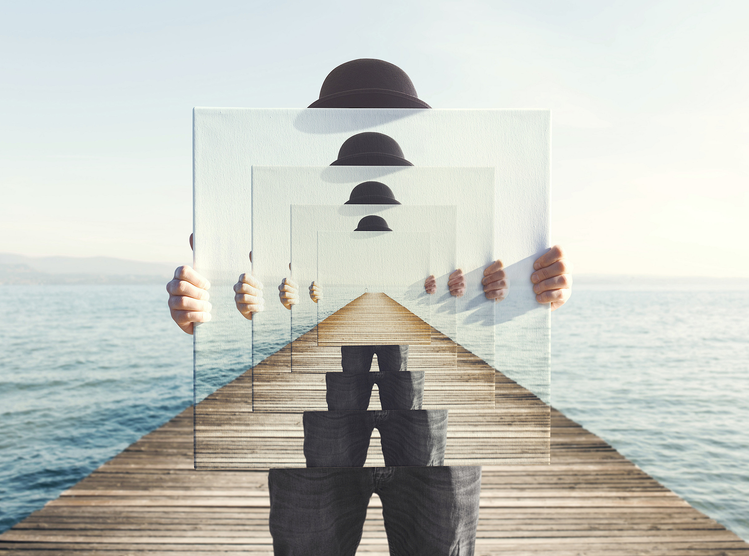 Mensch auf einem Steg ins Meer hält einen großen Spiegel in den Händen